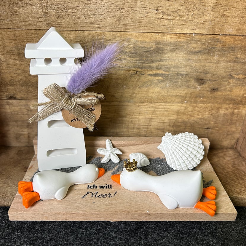 Handgefertigtes Entenpaar „Ich will Meer“ aus Gießkeramik mit Leuchtturm und Muscheldeko auf Holzplatte.