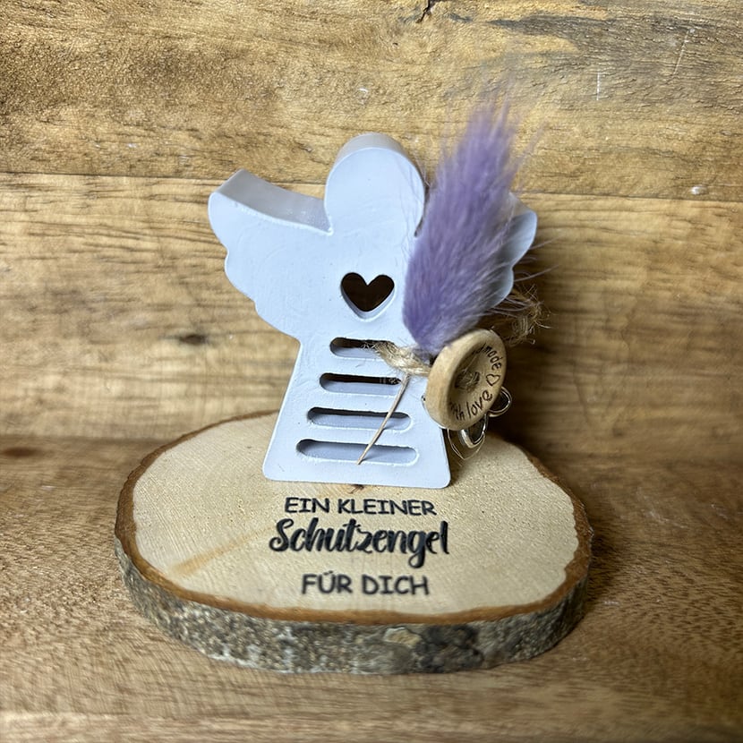 Handgefertigter kleiner Schutzengel für Dich aus Gießkeramik auf Holzscheibe mit Herzdetail und Trockenblume.