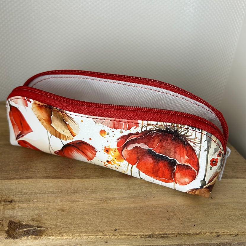 Zwei handgemachte lange Mäppchen – eines mit Mohnblumen-Design, eines mit schwarzem Regenbogen-Karo-Muster