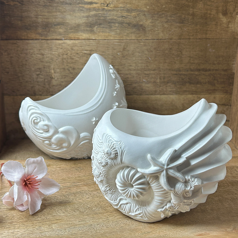 Zwei handgefertigte Schalen aus weißer Gießkeramik in Muschel- und Sternoptik mit maritimen Details