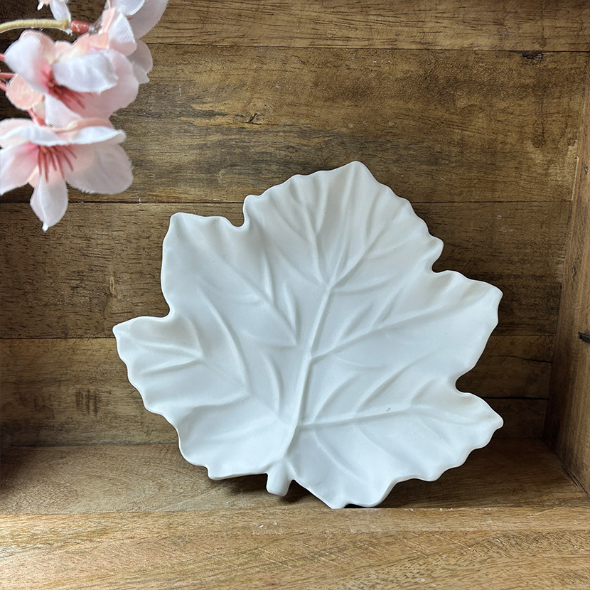 Weiße Seifenschale aus handgefertigter Gießkeramik in eleganter Ahornblatt-Form auf Holzuntergrund