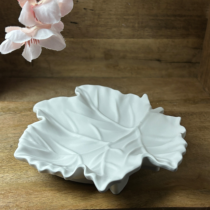 Weiße Seifenschale aus handgefertigter Gießkeramik in eleganter Ahornblatt-Form auf Holzuntergrund