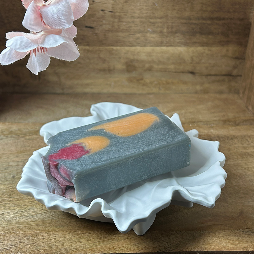 Weiße Seifenschale aus handgefertigter Gießkeramik in eleganter Ahornblatt-Form auf Holzuntergrund