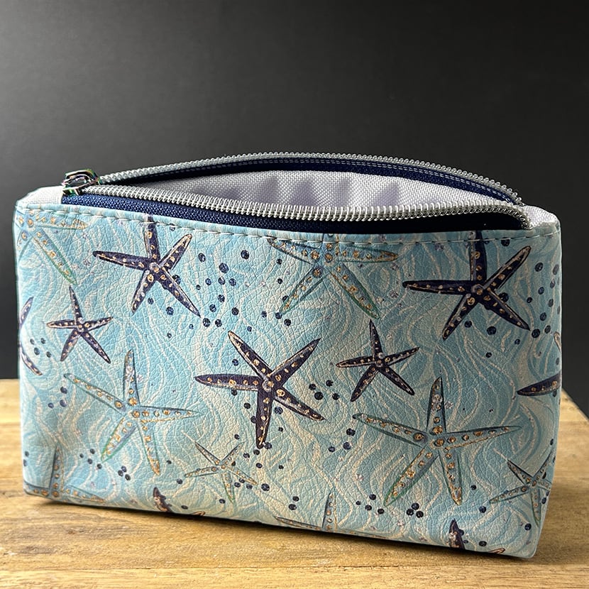 Handgenähte Mini-Kosmetiktasche mit Seesternen auf türkisblauem Kunstleder – wasserabweisend & ideal für unterwegs
