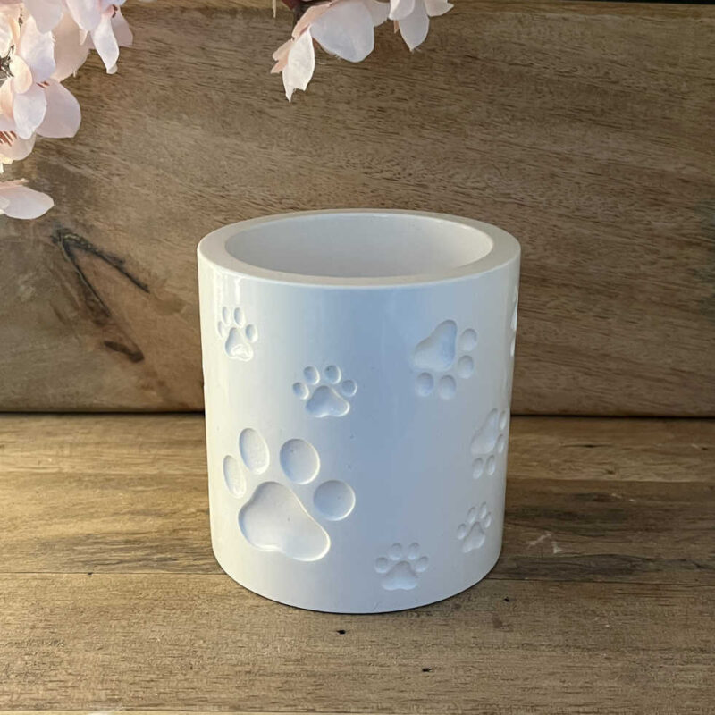 Weißer Deko-Becher mit mehreren Katzenpfoten-Motiven in Hauptansicht.