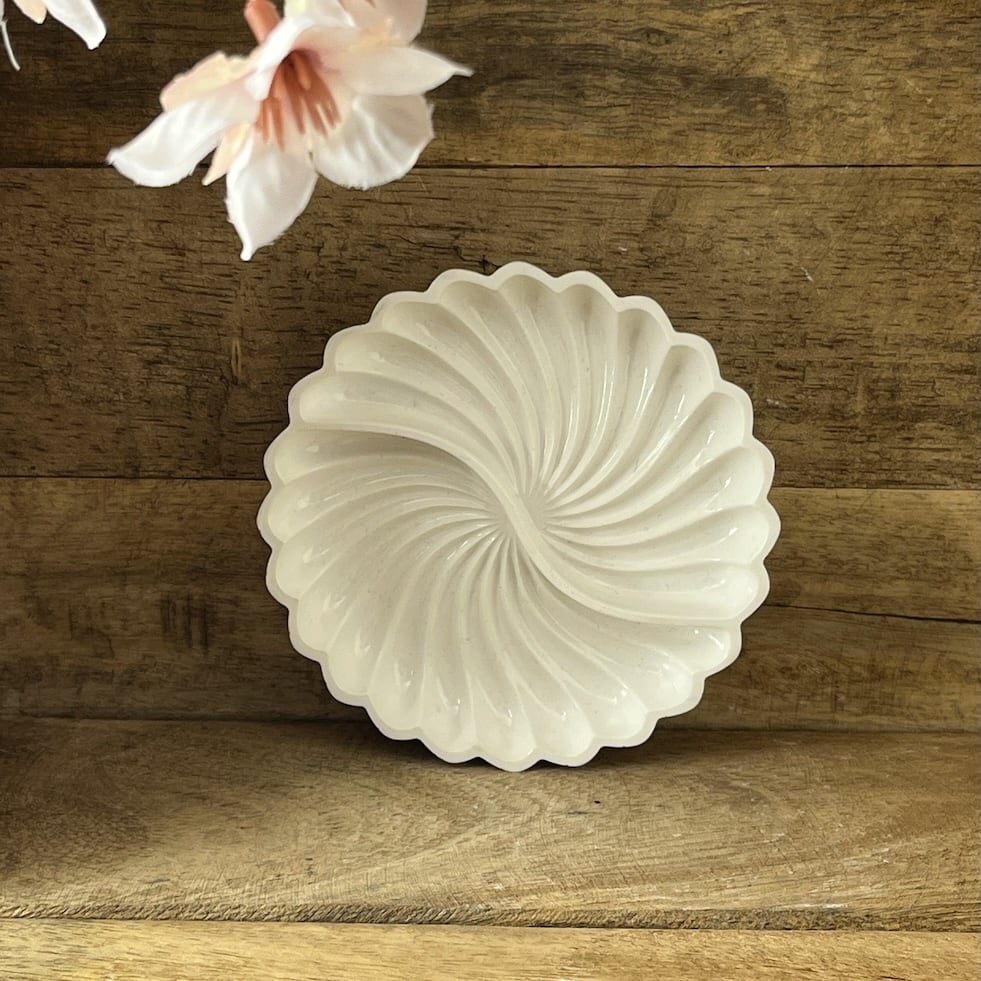 Kleine und große weiße Deko-Schale mit Spiralstruktur nebeneinander.